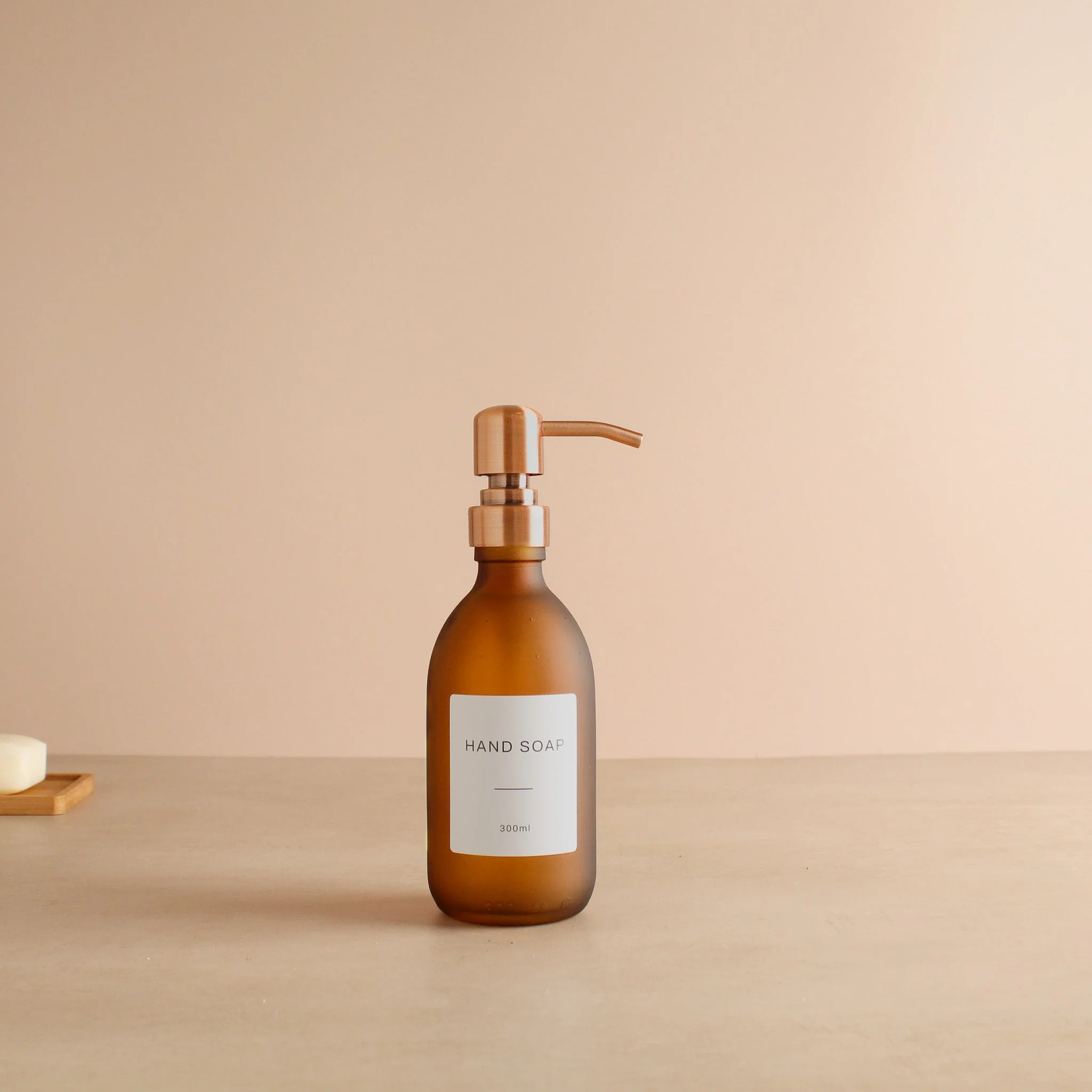Labelled Frosted Amber Glass Dispenser Bottle With Rose Gold Pump - Image 5