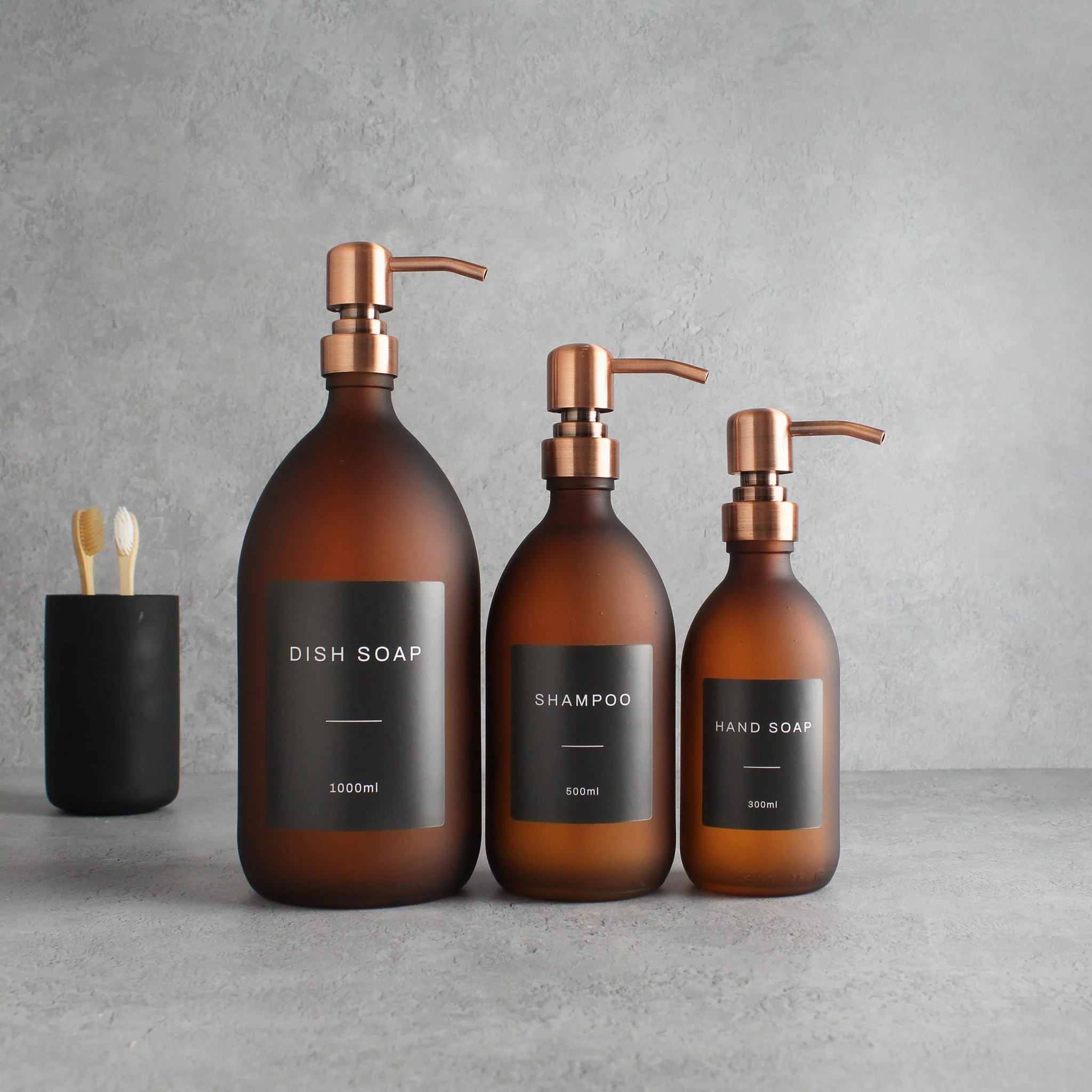 Labelled Frosted Amber Glass Dispenser Bottle With Rose Gold Pump - Image 2