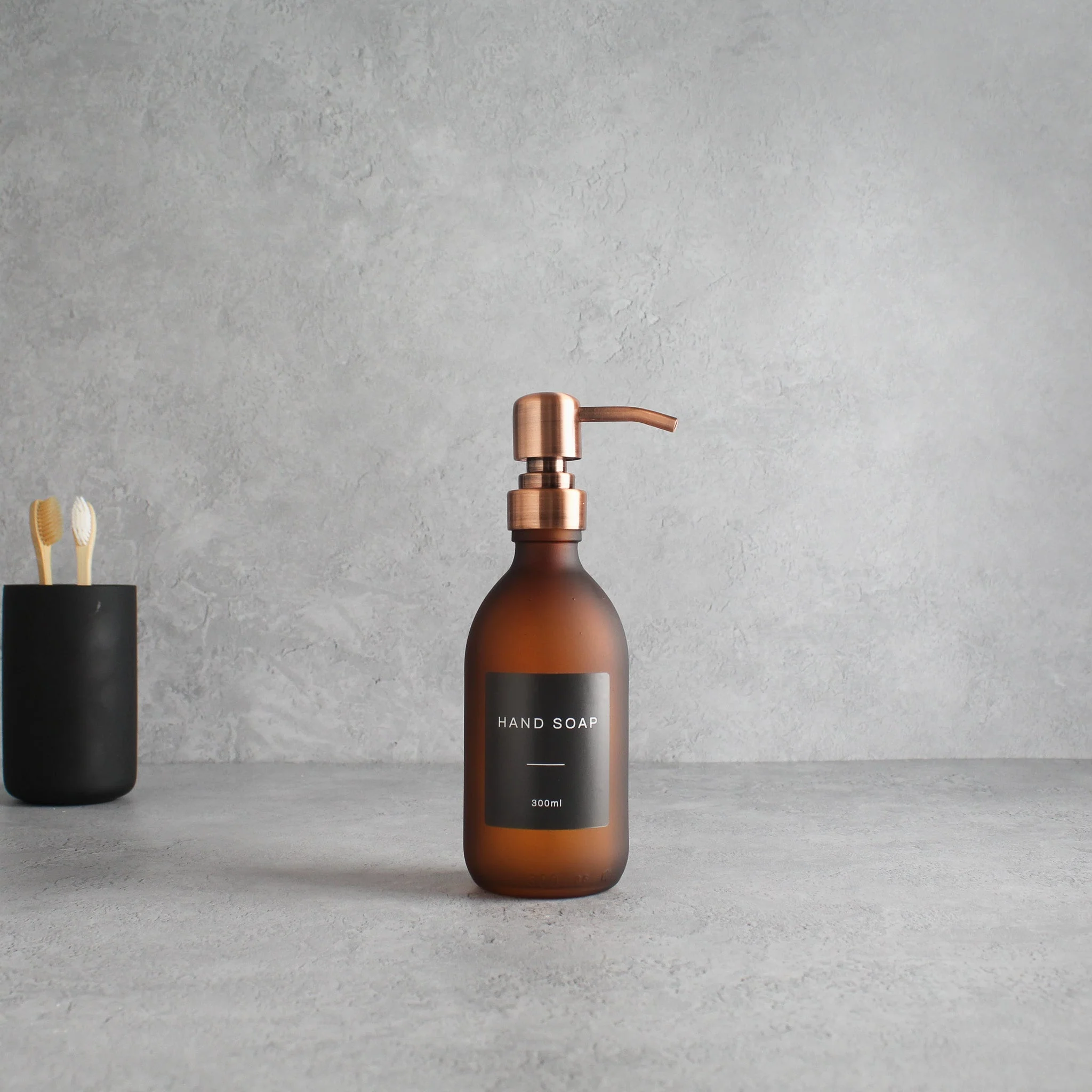 Labelled Frosted Amber Glass Dispenser Bottle With Rose Gold Pump - Image 5