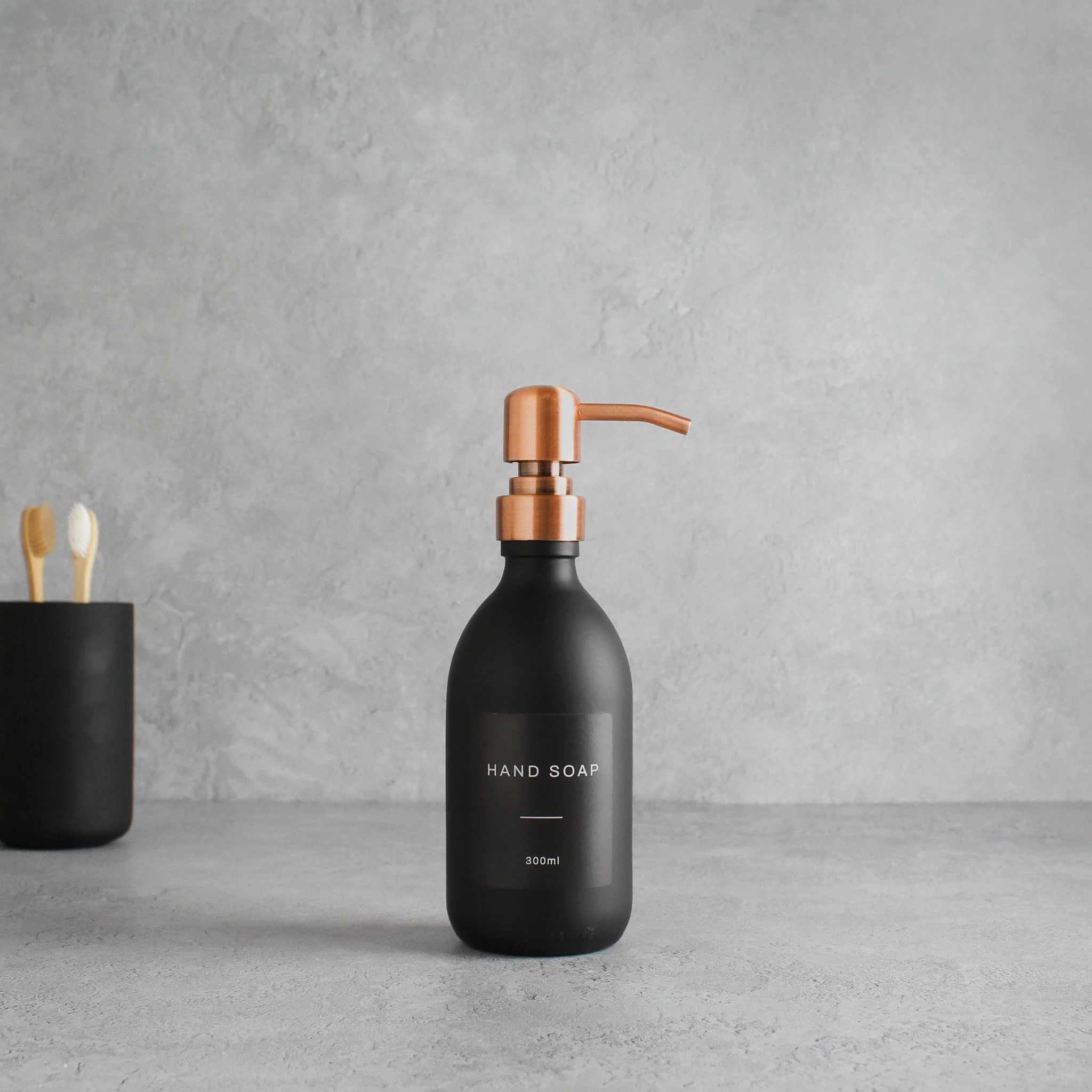 Labelled Matte Black Glass Dispenser Bottle With Rose Gold Pump - Image 5